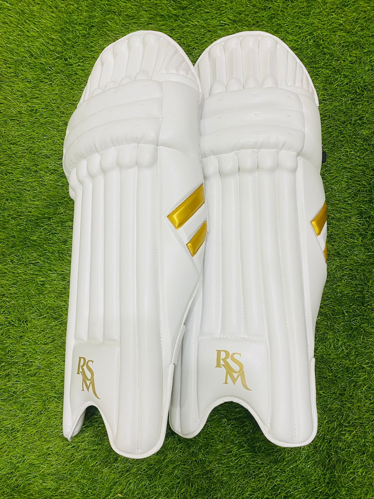 08558476-44e2-4157-b3a5-f74b8c673b10.jpg RSM CRICKET LEG GUARDS MEN SIZE WHITE & GOLD COLOR